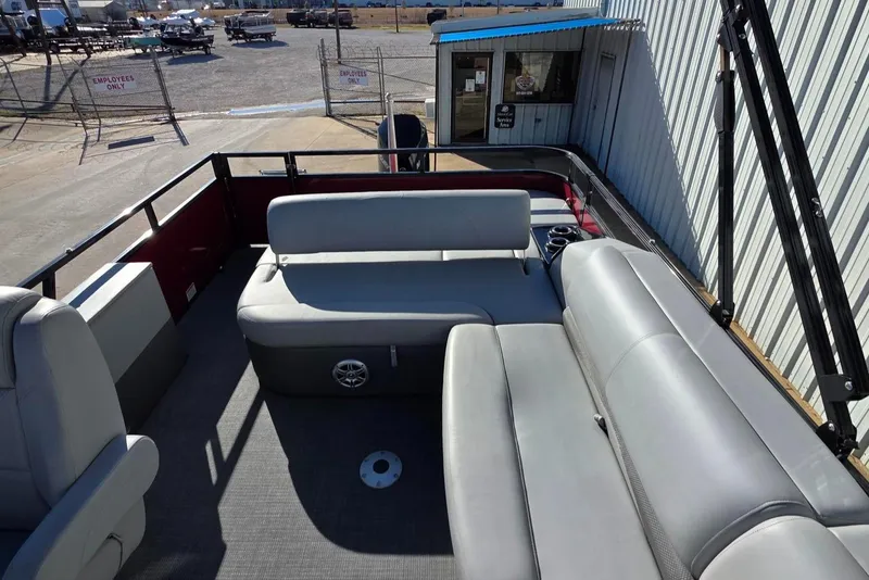 Slide: The Image of 2023 Regency 250 DL3 pontoon boat interior with gray seating and spacious layout. - 5