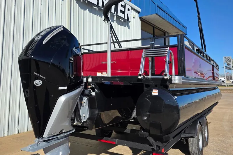 Slide: The Image of 2023 Regency 250 DL3 pontoon boat with powerful outboard motor, displayed outdoors. - 7