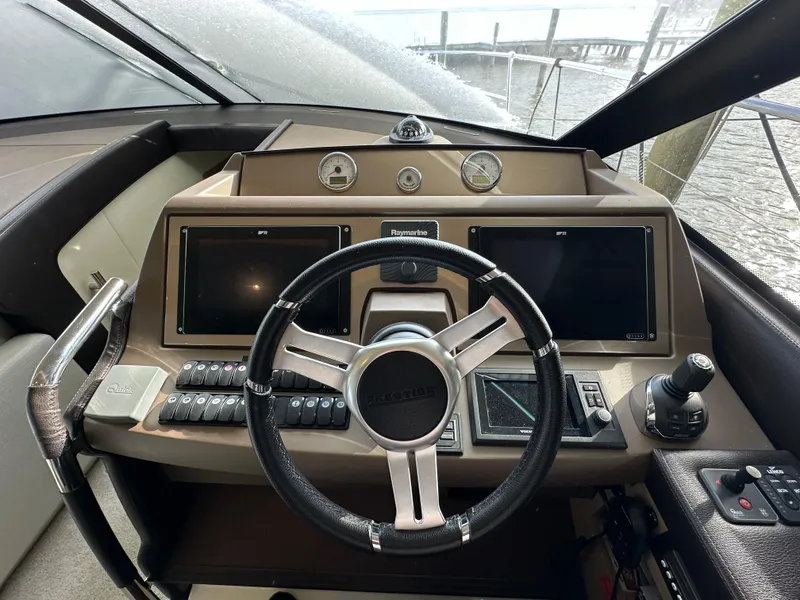 Slide: The Image of Steering wheel and dashboard of a 2017 Prestige 500 yacht, featuring modern navigation displays. - 10