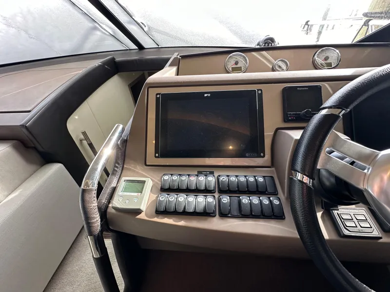 Slide: The Image of Control panel of a 2017 Prestige 500 yacht with steering wheel and navigation display. - 11
