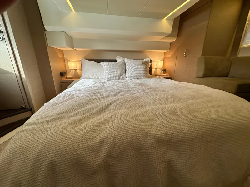Slide: The Image of Luxurious bedroom interior in a 2017 Prestige 500 yacht, featuring elegant bedding and ambient lighting. - 21