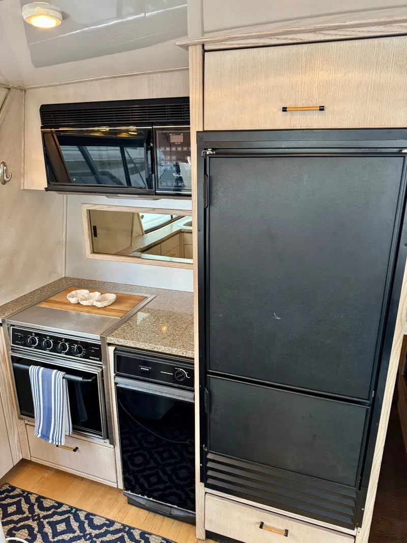 Slide: The Image of 1996 Bayliner 4788 Pilothouse kitchen with stove, oven, and refrigerator. - 10
