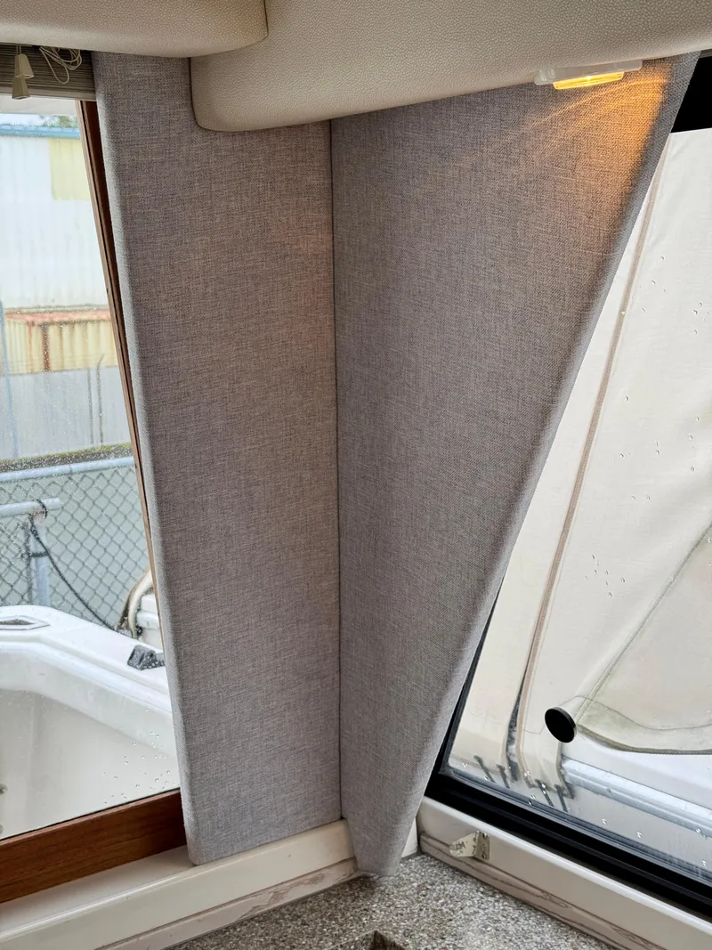 Slide: The Image of Interior view of a 1996 Bayliner 4788 Pilothouse with gray curtains and window. - 13