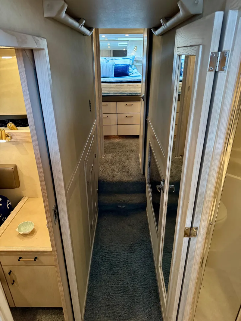Slide: The Image of Interior hallway of 1996 Bayliner 4788 Pilothouse yacht, featuring carpeted flooring and wooden cabinetry. - 14