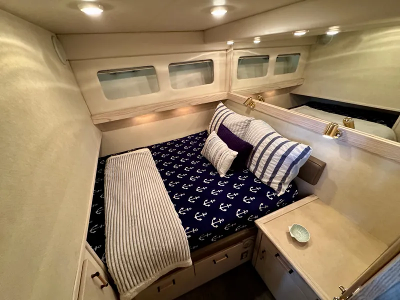 Slide: The Image of 1996 Bayliner 4788 Pilothouse bedroom with nautical-themed bedding and cozy lighting. - 18