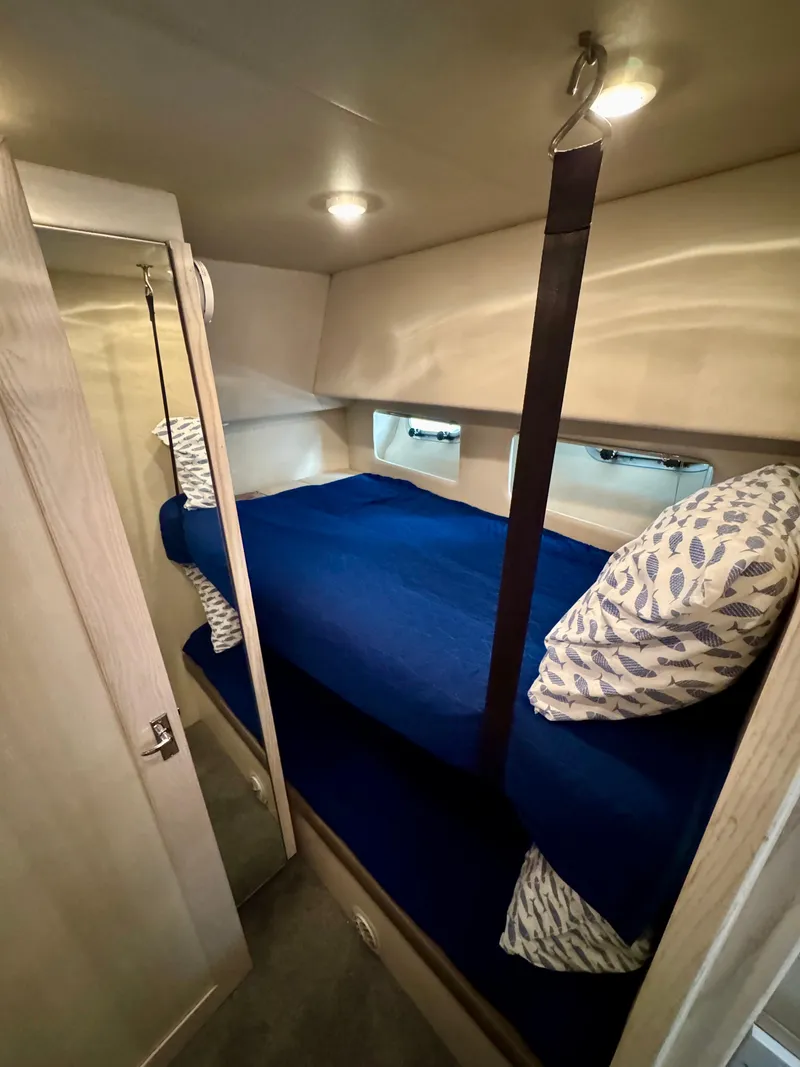 Slide: The Image of Cozy bunk beds in 1996 Bayliner 4788 Pilothouse cabin with blue bedding and patterned pillows. - 19