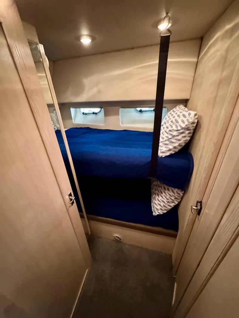 Slide: The Image of 1996 Bayliner 4788 Pilothouse cabin with bunk beds and blue bedding. - 20