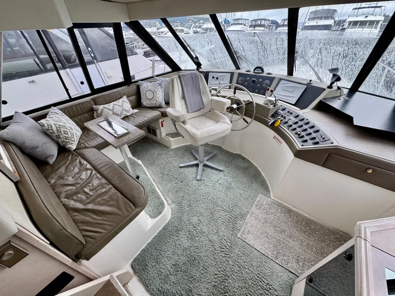 Slide: The Image of 1996 Bayliner 4788 Pilothouse interior with helm, seating, and panoramic windows. - 21