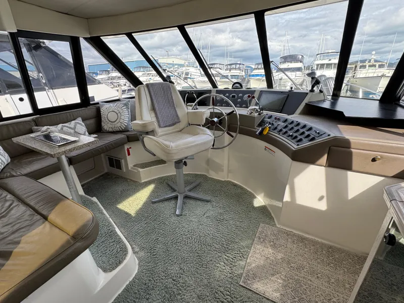 Slide: The Image of 1996 Bayliner 4788 Pilothouse interior with helm, seating, and panoramic windows. - 22
