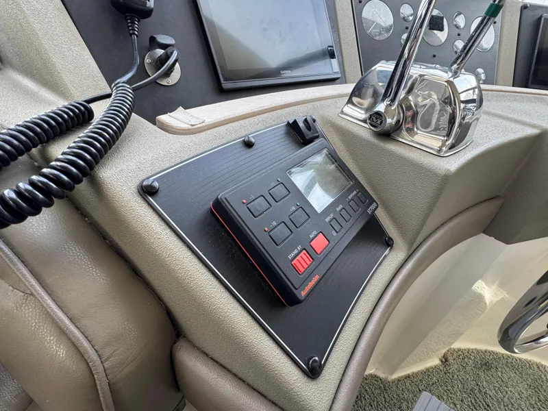 Slide: The Image of 1996 Bayliner 4788 Pilothouse helm with control panel and throttle levers. - 26