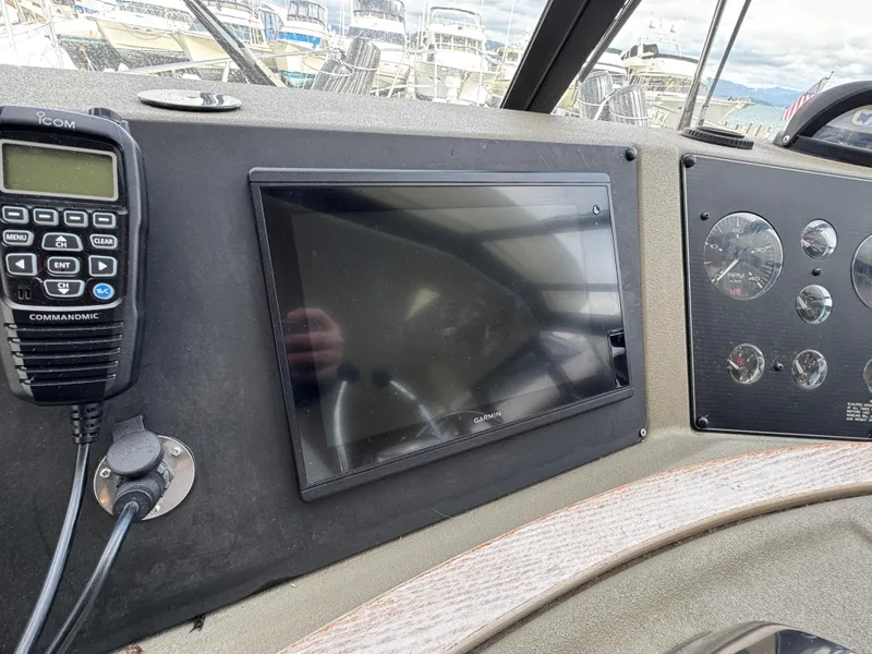 Slide: The Image of 1996 Bayliner 4788 Pilothouse dashboard with navigation screen and radio controls. - 27