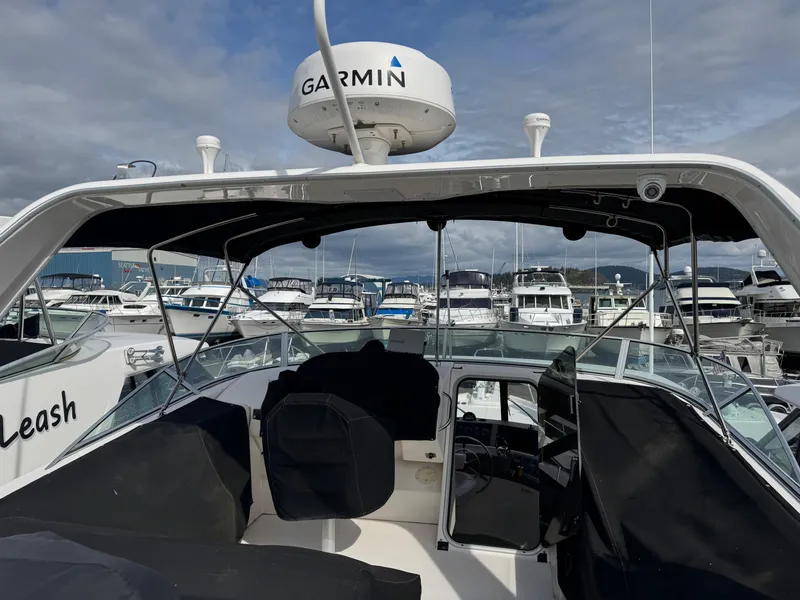Slide: The Image of 1996 Bayliner 4788 Pilothouse yacht with Garmin radar, docked at a marina under cloudy skies. - 31