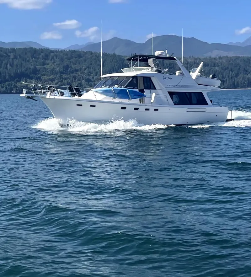 Slide: The Image of 1996 Bayliner 4788 Pilothouse cruising on a scenic lake with mountainous backdrop. - 5