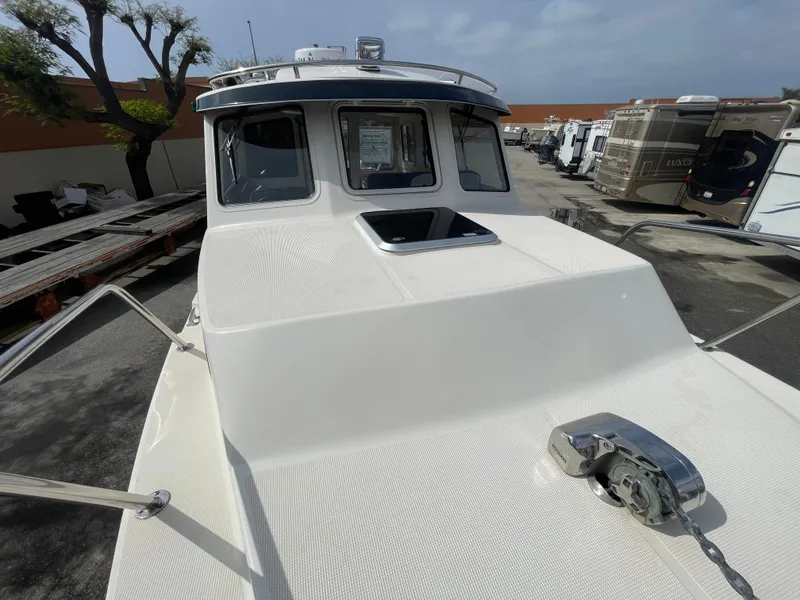 Slide: The Image of 2009 C-Dory TOMCAT 255 boat, front deck view with anchor, in a parking area. - 14