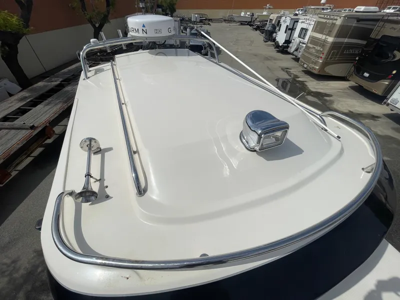 Slide: The Image of 2009 C-Dory TOMCAT 255 boat deck with railing and hatch, parked in a lot. - 17