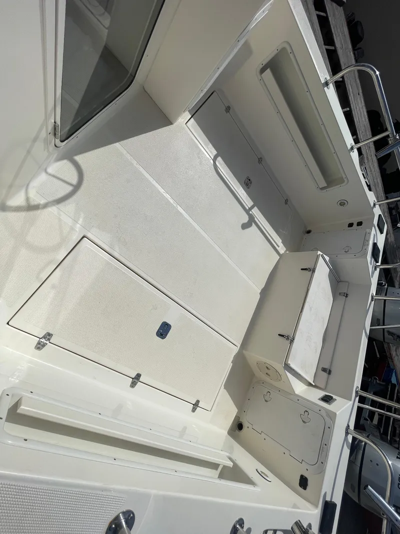 Slide: The Image of 2009 C-Dory TOMCAT 255 boat interior, featuring spacious deck and storage compartments. - 20
