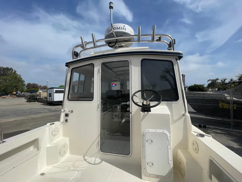 Slide: The Image of 2009 C-Dory TOMCAT 255 boat with Garmin equipment, docked under a clear sky. - 21