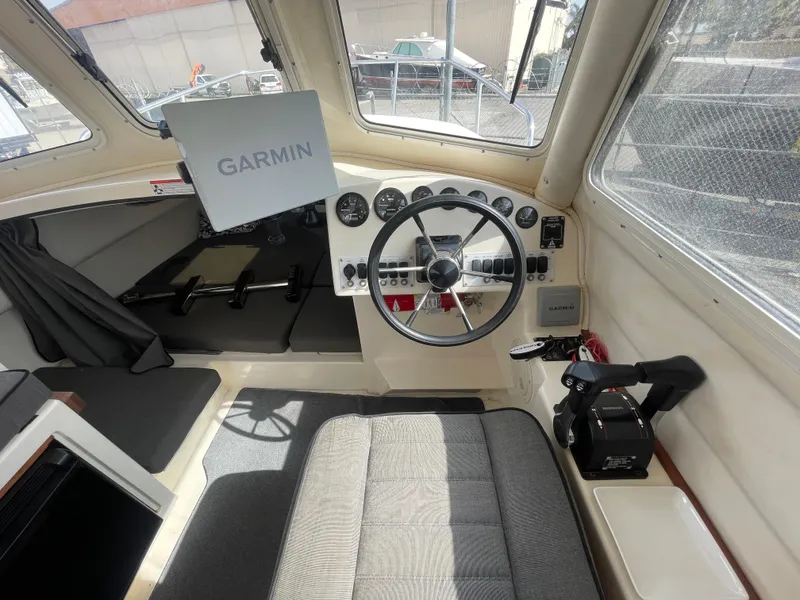 Slide: The Image of 2009 C-Dory TOMCAT 255 boat interior with Garmin navigation system and steering wheel. - 23