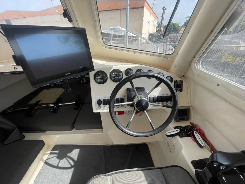 Slide: The Image of 2009 C-Dory TOMCAT 255 boat cockpit with steering wheel and control panel. - 24
