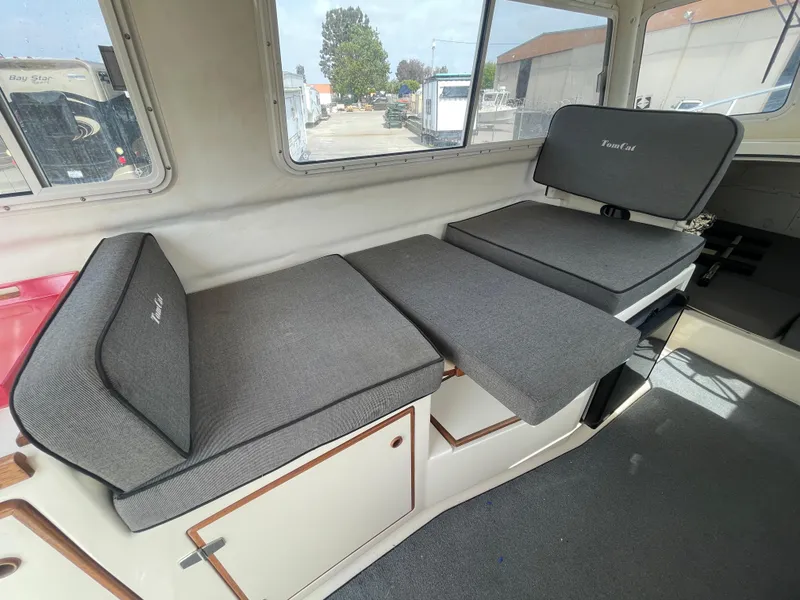 Slide: The Image of 2009 C-Dory TOMCAT 255 interior with gray cushioned seating and windows. - 30
