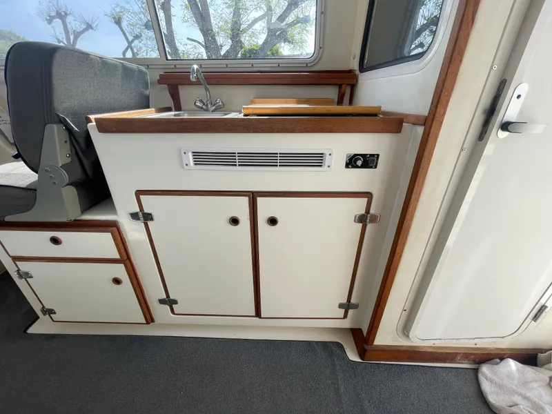 Slide: The Image of 2009 C-Dory TOMCAT 255 interior with kitchenette and seating area. - 35