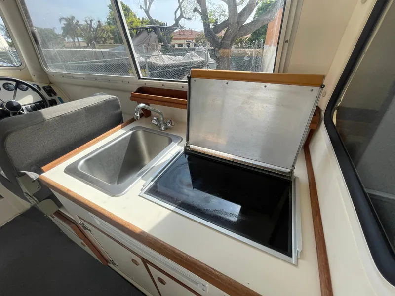 Slide: The Image of 2009 C-Dory TOMCAT 255 boat interior with sink and stove in the galley area. - 38