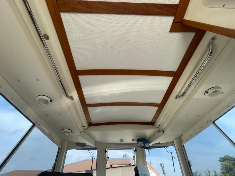 Slide: The Image of Interior ceiling of 2009 C-Dory TOMCAT 255 boat with wooden accents and windows. - 39