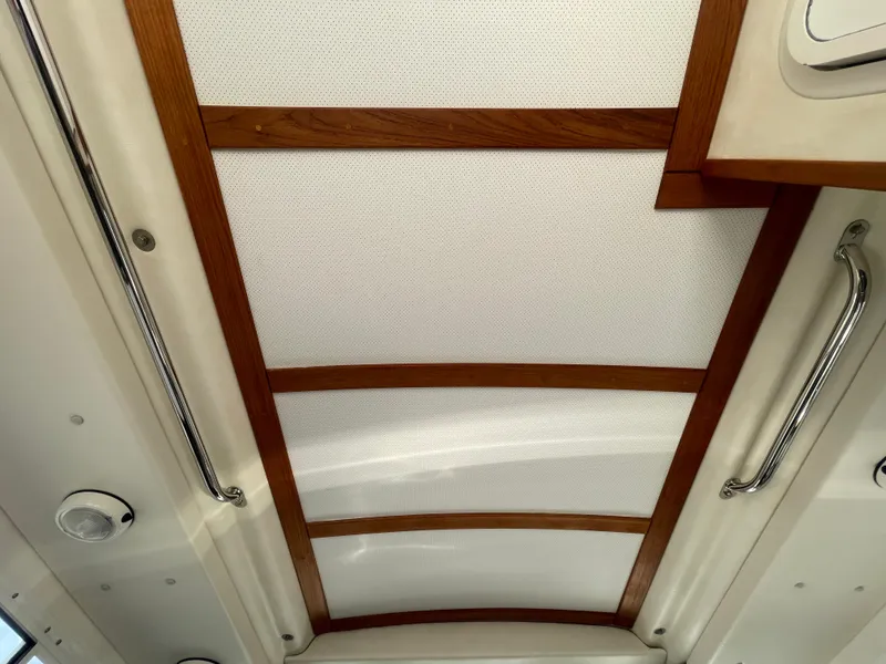 Slide: The Image of 2009 C-Dory TOMCAT 255 interior ceiling with wood accents and metal handles. - 40