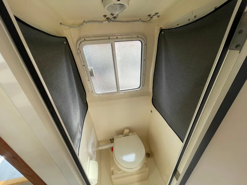 Slide: The Image of 2009 C-Dory TOMCAT 255 boat bathroom with window and compact toilet. - 41