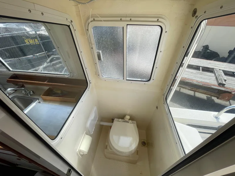 Slide: The Image of 2009 C-Dory TOMCAT 255 boat interior with compact bathroom and windows. - 44