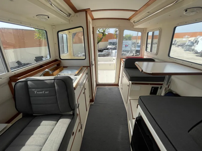 Slide: The Image of Interior of 2009 C-Dory TOMCAT 255 boat, featuring seating and kitchenette. - 45
