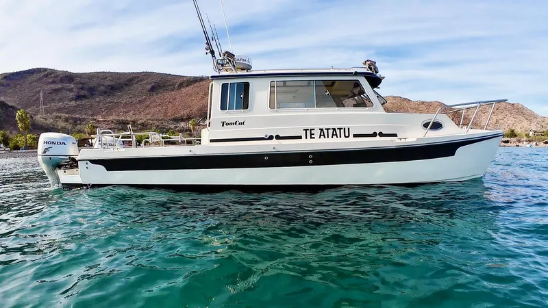 Slide: The Image of 2009 C-Dory TOMCAT 255 boat on water, side view, with Honda outboard motor. - 64
