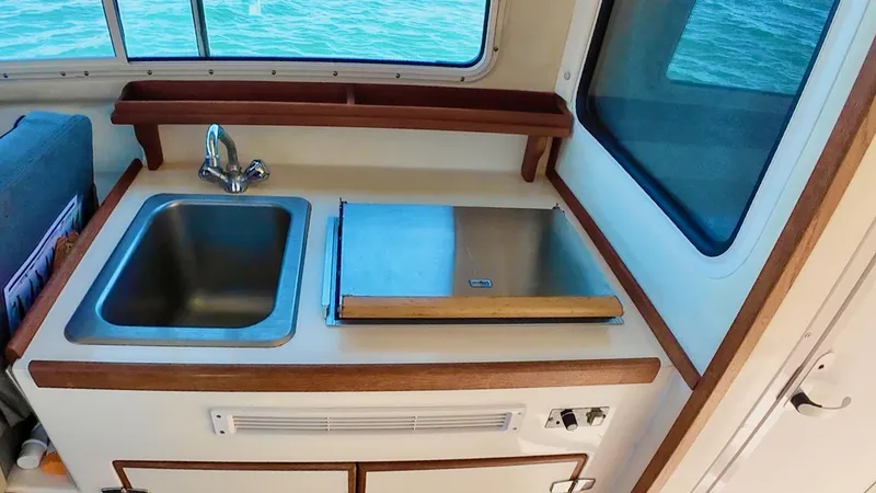 Slide: The Image of 2009 C-Dory TOMCAT 255 boat kitchen with sink and stove. - 77