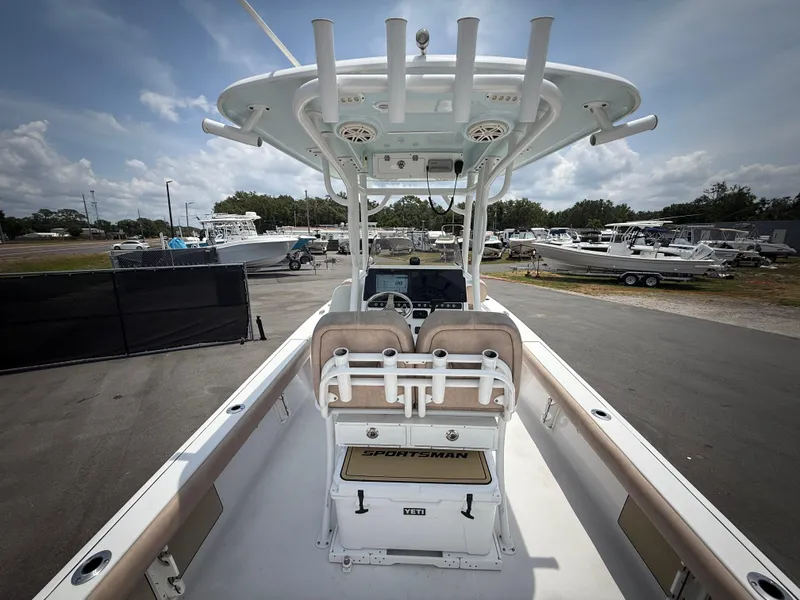 Slide: The Image of 2020 Sportsman Masters 247 Bay Boat interior with seating and console, parked outdoors. - 14