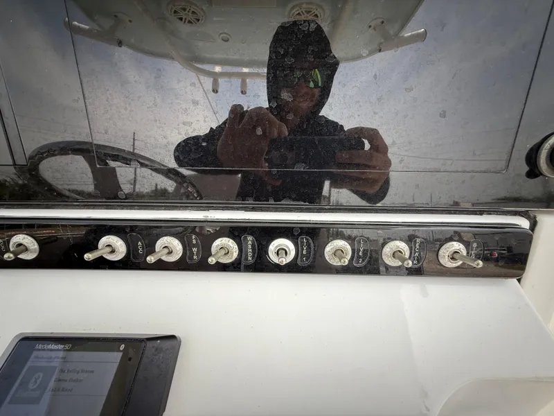 Slide: The Image of Control panel of a 2020 Sportsman Masters 247 Bay Boat with reflection of a person. - 25