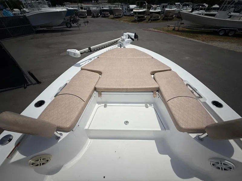 Slide: The Image of 2020 Sportsman Masters 247 Bay Boat with cushioned seating and trolling motor, parked in a marina. - 31