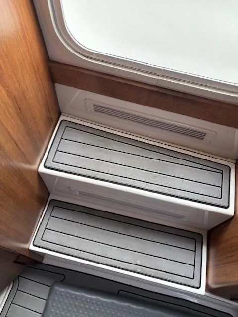 Slide: The Image of Steps inside a 2018 Invincible 42 CC boat, featuring wood paneling and non-slip surfaces. - 12