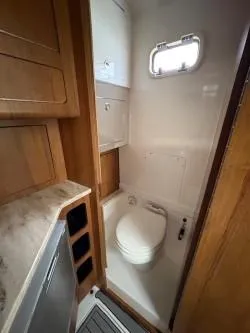 Slide: The Image of Compact bathroom in 2018 Invincible 42 CC boat with wooden cabinetry and modern fixtures. - 16
