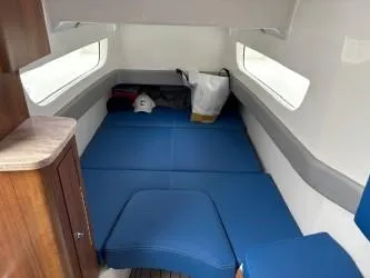 Slide: The Image of 2018 Invincible 42 CC cabin interior with blue seating and storage space. - 18