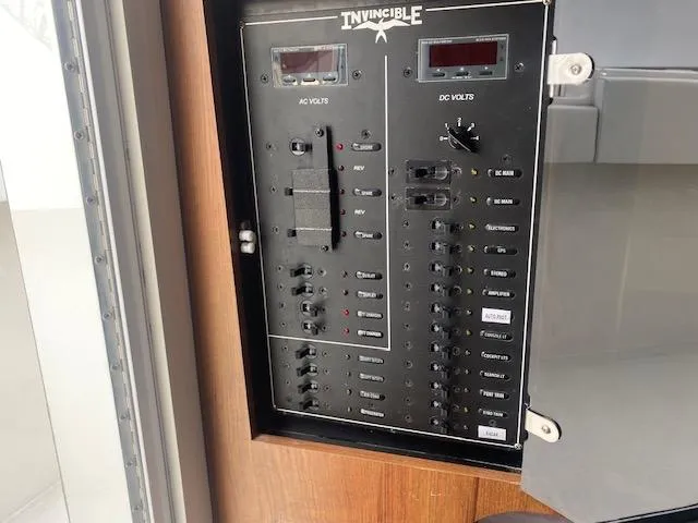 Slide: The Image of Electrical control panel of a 2018 Invincible 42 CC boat, featuring AC and DC volt meters. - 20
