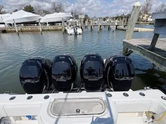 Slide: The Image of 2018 Invincible 42 CC boat with four powerful outboard engines docked at a marina. - 24