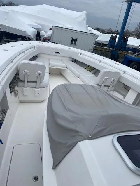 Slide: The Image of 2018 Invincible 42 CC boat with covered seating, docked outdoors. - 3