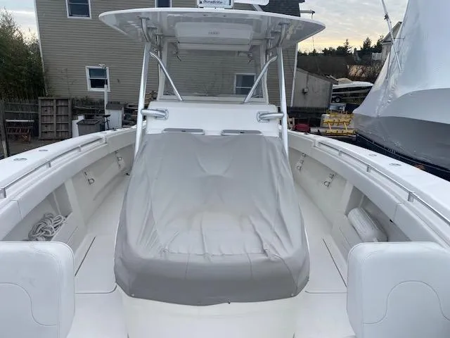 Slide: The Image of 2018 Invincible 42 CC boat with covered seating area, docked near residential buildings. - 4