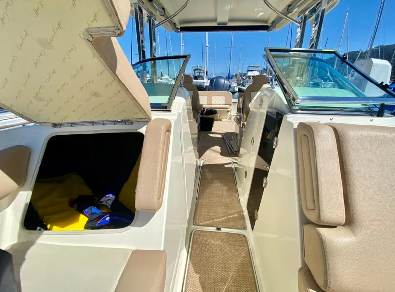 Slide: The Image of 2020 Chris-Craft Calypso 26 interior with beige seating and open storage compartment. - 16