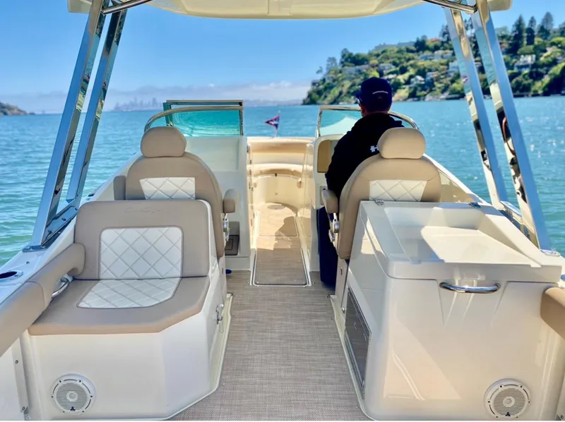 Slide: The Image of 2020 Chris-Craft Calypso 26 boat interior with seating, on a sunny day at sea. - 19