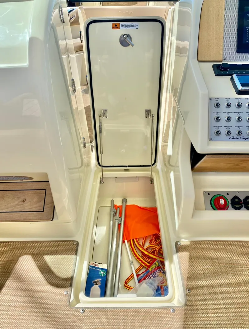 Slide: The Image of 2020 Chris-Craft Calypso 26 storage compartment with safety equipment and accessories. - 29