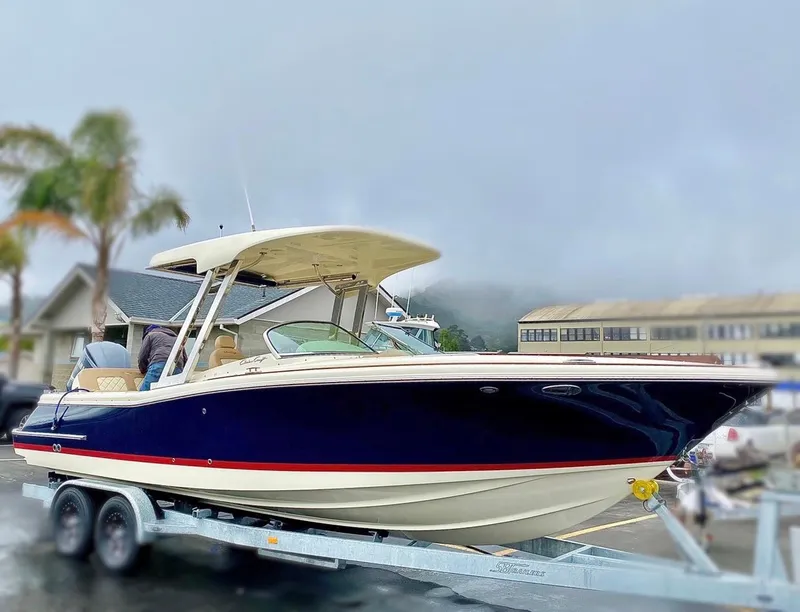Slide: The Image of 2020 Chris-Craft Calypso 26 boat on trailer, parked outdoors. - 36