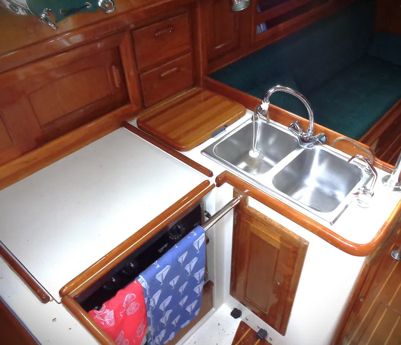 Slide: The Image of 1987 Pacific Seacraft 34 yacht galley with wooden cabinetry and dual sink. - 3