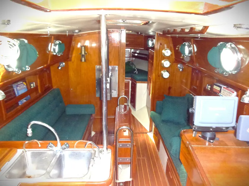 Slide: The Image of Interior of 1987 Pacific Seacraft 34 sailboat with wood finish and green upholstery. - 1
