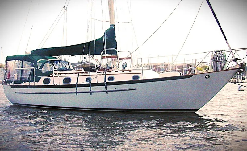The Image of 1987 Pacific Seacraft 34 sailboat on water, featuring classic design and green canopy. - 0